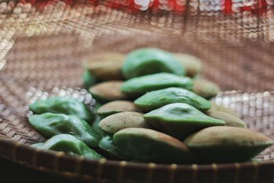 Close-up of green chili peppers in basket at market