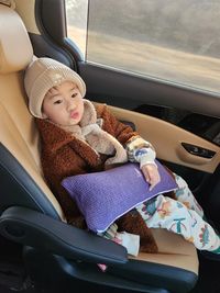 Portrait of cute girl sitting in car