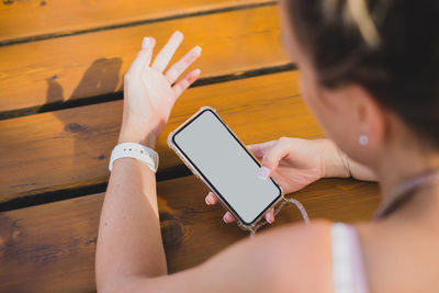 Midsection of woman using mobile phone on table