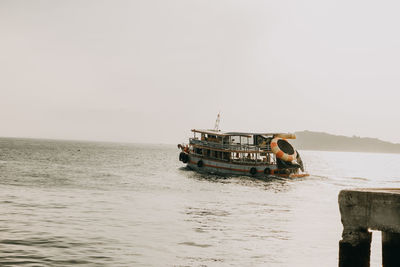 Boat sailing on sea against clear sky