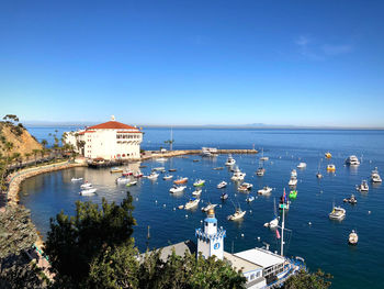 High angle view of sea by buildings against clear blue sky