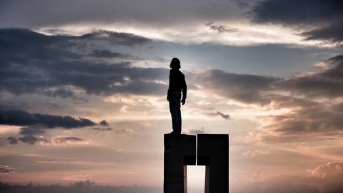 Low angle view of silhouette man standing against sky