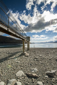 Metallic structure on beach against sky