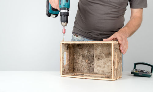 Midsection of man working against white background