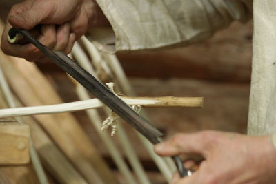 Midsection of man working on wood