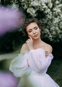 A beautiful delicate elegant woman bride in a wedding dress walks alone in a spring outdoor park