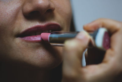 Close-up of woman applying lipstick