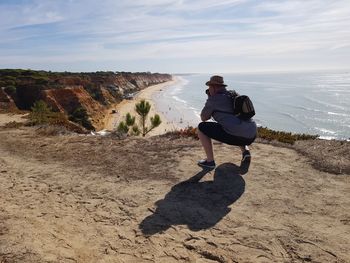 Full length of man on land by sea against sky