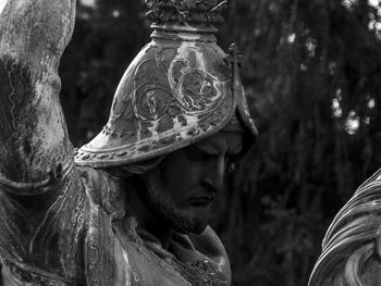 Close-up portrait of statue against trees