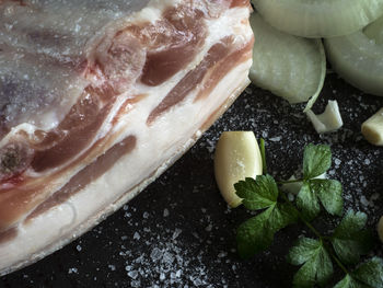 Directly above shot of rib meat with garlic and herbs on table