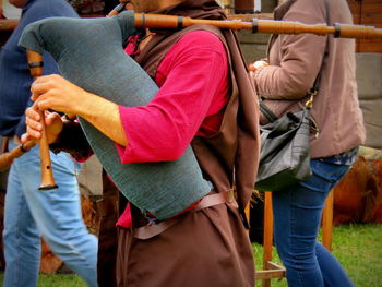 Midsection of person playing bagpiper during medieval fair