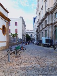 Cars on street in city against sky