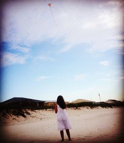 Rear view of woman walking on beach