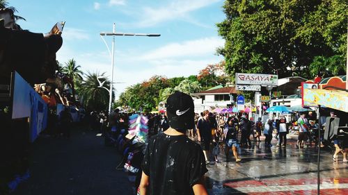 Crowd on street in city against sky