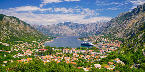 High angle view of townscape by lake against mountains