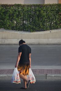 Rear view of woman walking on street in city