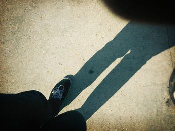 Low section of person standing on road