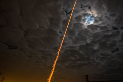 Low angle view of vapor trails against sky at night