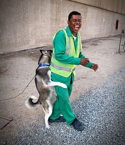 Construction worker playing with dog at site