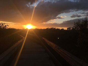 Railroad tracks against sky during sunset