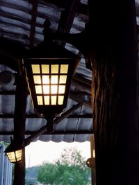 Illuminated lantern hanging on ceiling of building