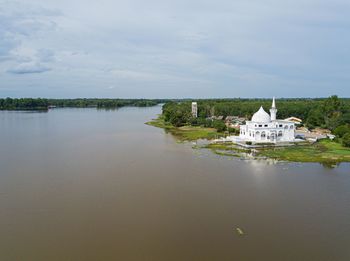 Building by lake against sky