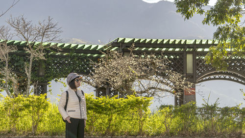 Woman standing by plants against sky