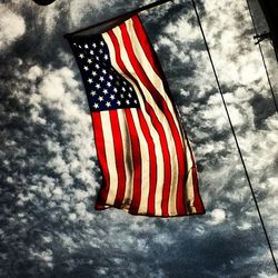 Low angle view of american flag against sky