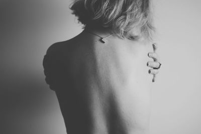 Rear view of shirtless woman against white background