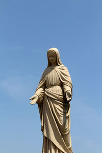 Low angle view of statue against blue sky