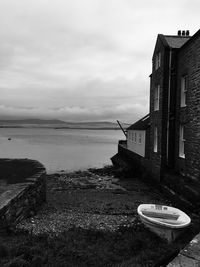 Abandoned building by sea against sky