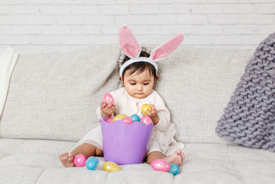 Cute girl wearing costume sitting on sofa