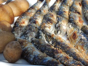 High angle view of fish sardines and potatoes on plate