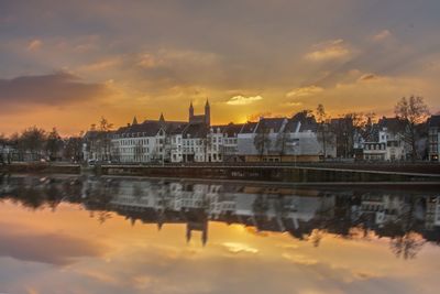 Reflection of buildings in water at sunset