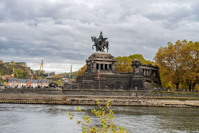 Statue of historic building against cloudy sky