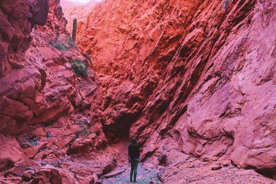 Woman standing in a red canyon at quebrada de las señoritas in northwest argentina near humahuaca.