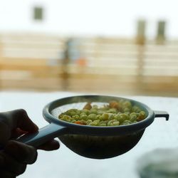 Close-up of hand holding salad in bowl