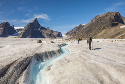 Rear view of climbers approaching mt. loki, baffin island, canada.