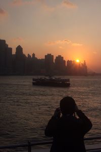 Silhouette of people in river at sunset