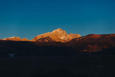 Scenic view of snowcapped mountains against clear blue sky