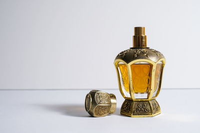 Close-up of glass bottle on table against white background