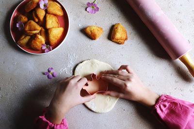 Cropped hand of person preparing food on table