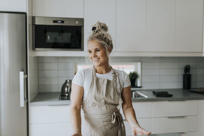 Smiling woman standing in kitchen