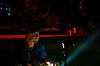 Young man playing guitar at night