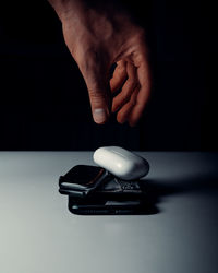 Close-up of human hand on table against black background