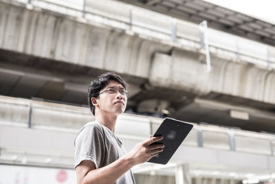 Side view of young man looking at camera