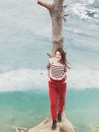 Full length of woman standing by sea