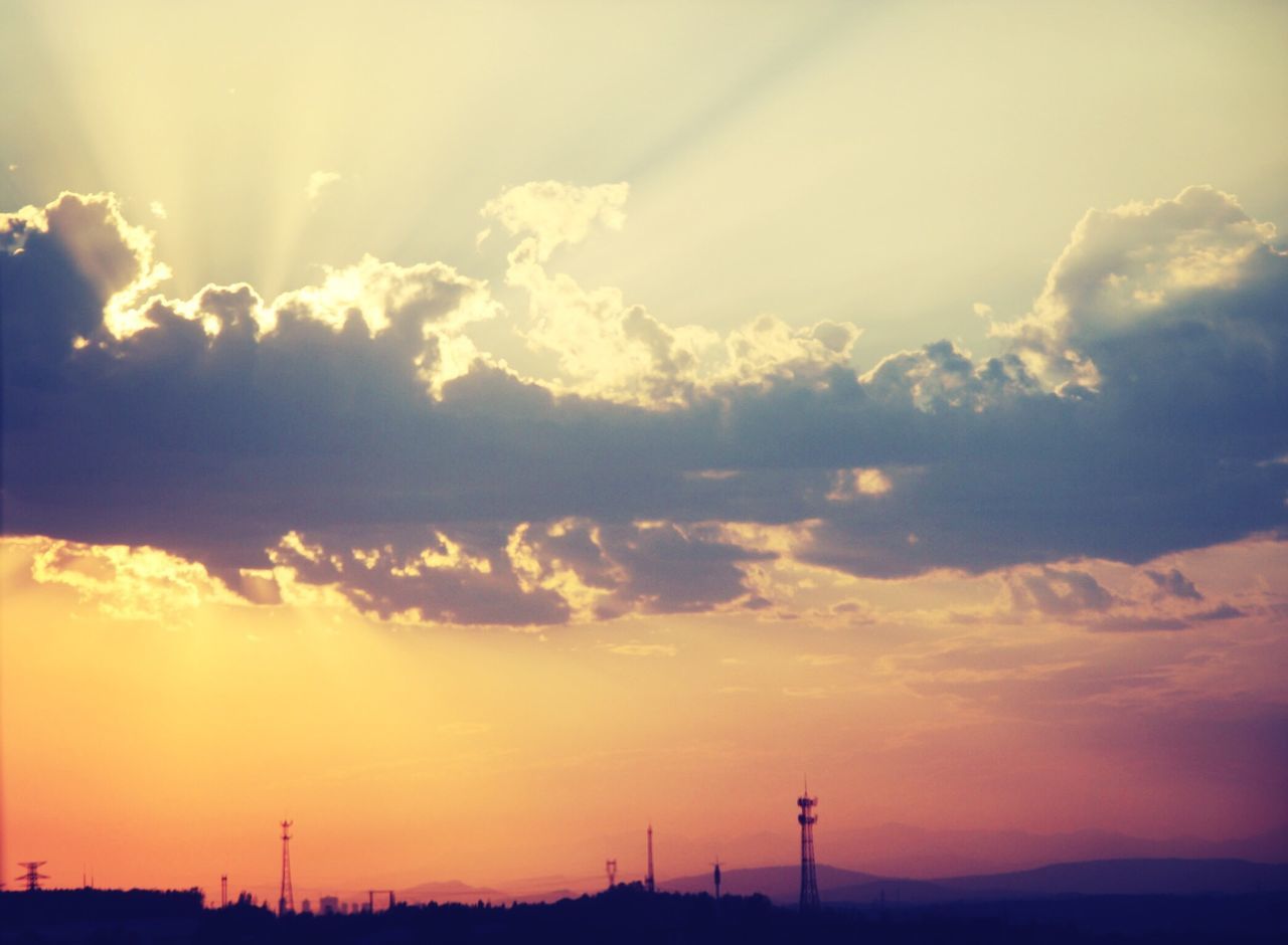 sunset, silhouette, sky, scenics, tranquil scene, beauty in nature, tranquility, landscape, orange color, nature, cloud - sky, idyllic, sun, cloud, dramatic sky, low angle view, outdoors, sunlight, electricity pylon, field