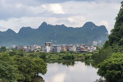 Houses by lake against sky