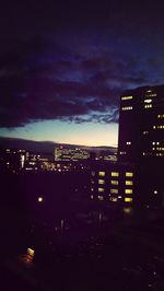 Illuminated cityscape against sky at night